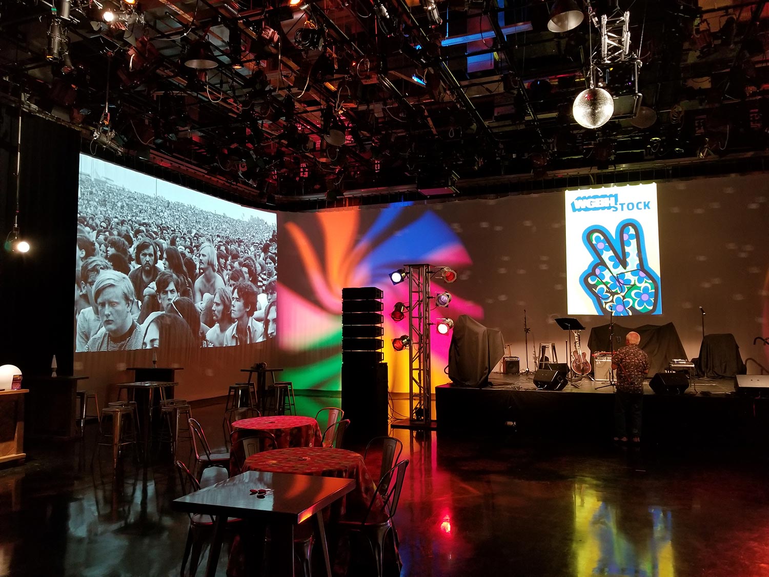 Event stage with colorful lighting and large projection screens in a studio setting