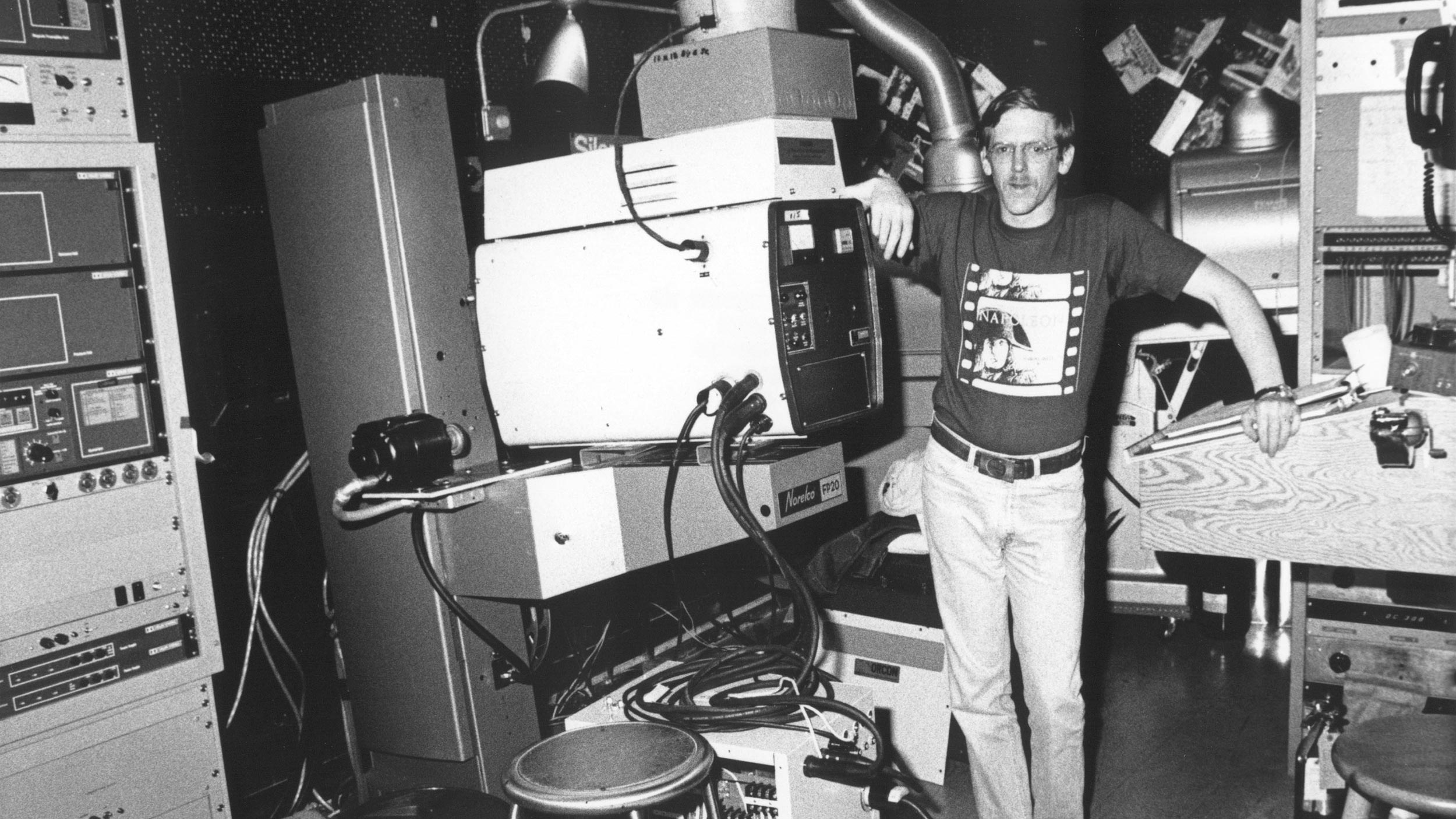 Man posing with vintage film projection equipment and audio gear