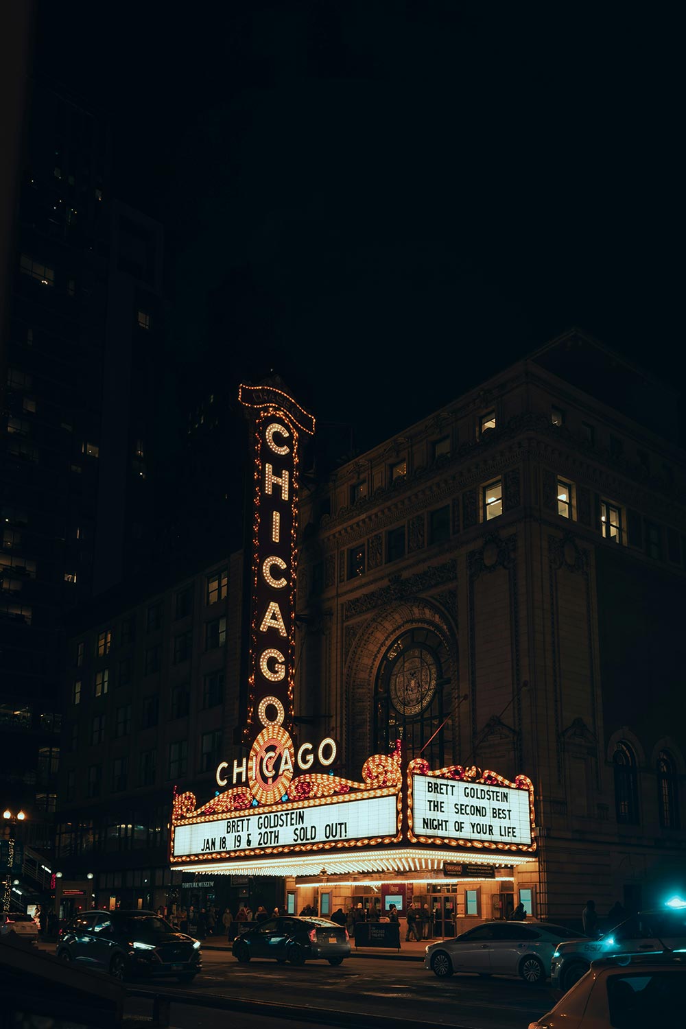 Night view of Chicago Theatre with illuminated marquee and vertical sign
