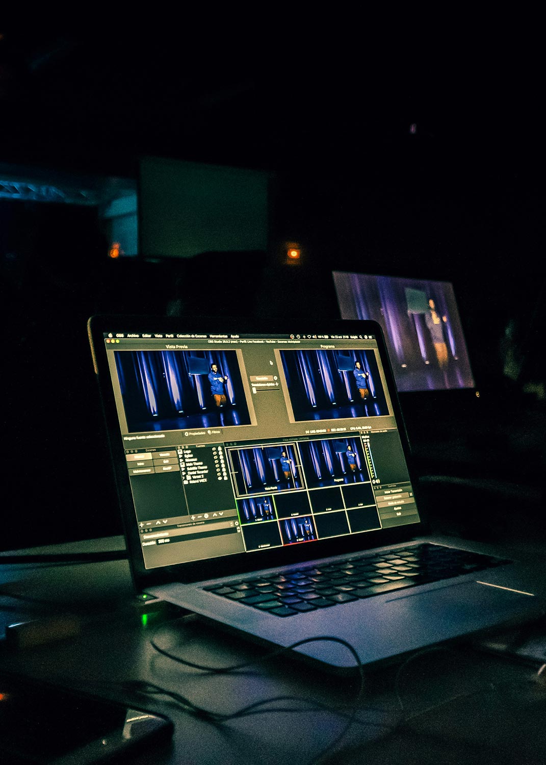 A laptop screen displaying a live-streaming video production setup at an event.