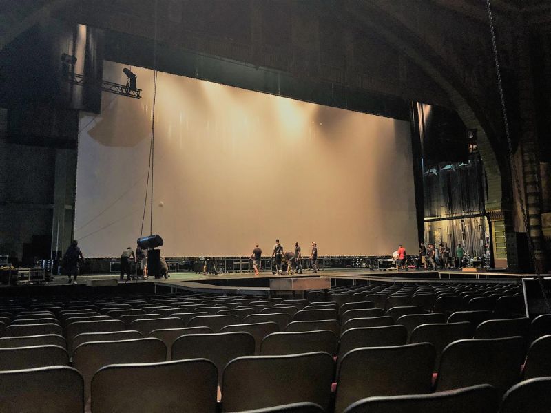 Crew setting up a giant projection screen inside a theater