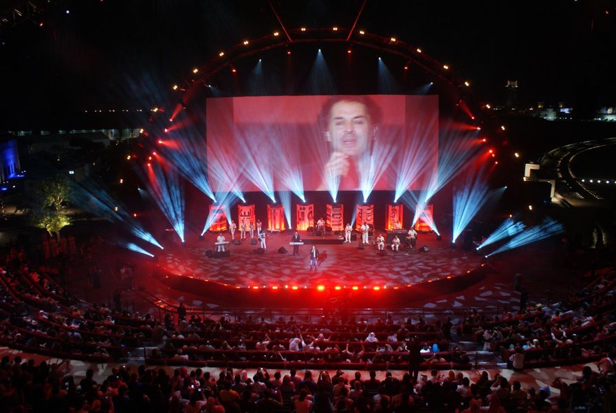 Live concert with vibrant stage lighting and large screen display