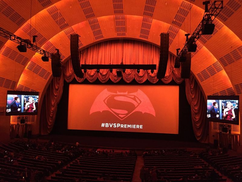 Theater interior with orange lighting showing Batman v Superman premiere