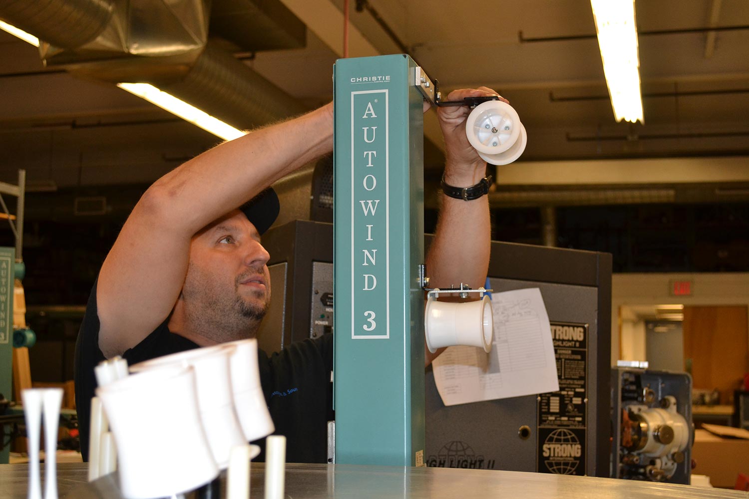 Technician adjusting reel components on a Christie Autowind 3 film equipment unit
