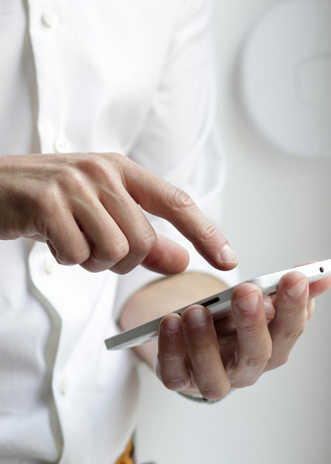 A person using a smartphone, wearing a white shirt.