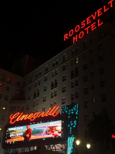 Neon-lit Roosevelt Hotel and Cinegrill sign with movie billboard