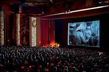 Classic film playing in grand theater with audience seated below