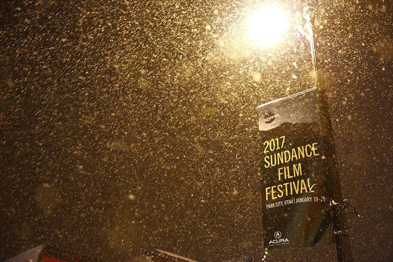 Snow falling under streetlight with 2017 Sundance Film Festival banner