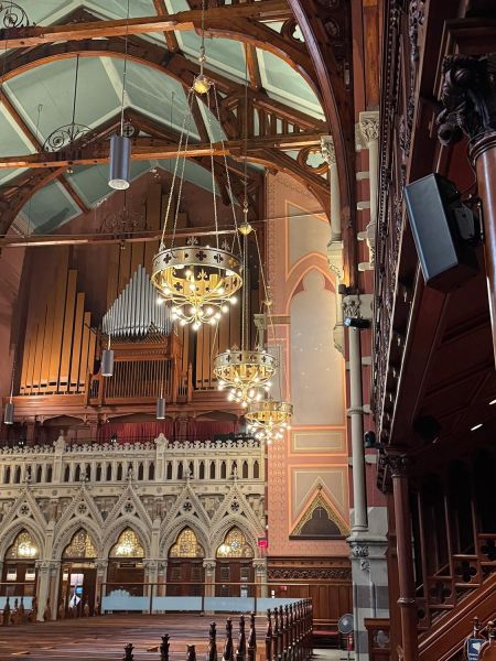 Church interior with decorative chandeliers and mounted speakers