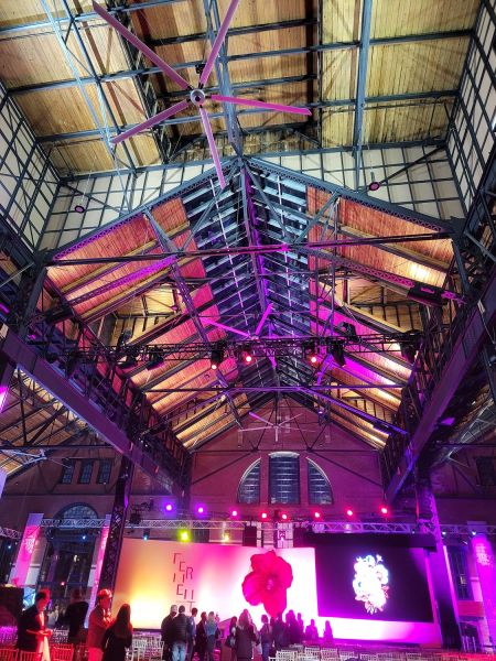 Industrial ceiling view of event space with lights and wooden rafters
