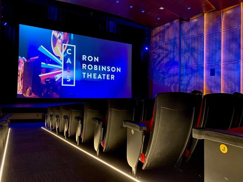 Theater screen displaying Ron Robinson Theater logo with rows of seats in foreground