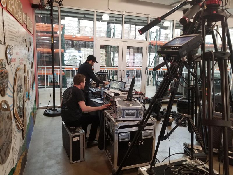 Two technicians operating camera and sound equipment at a venue
